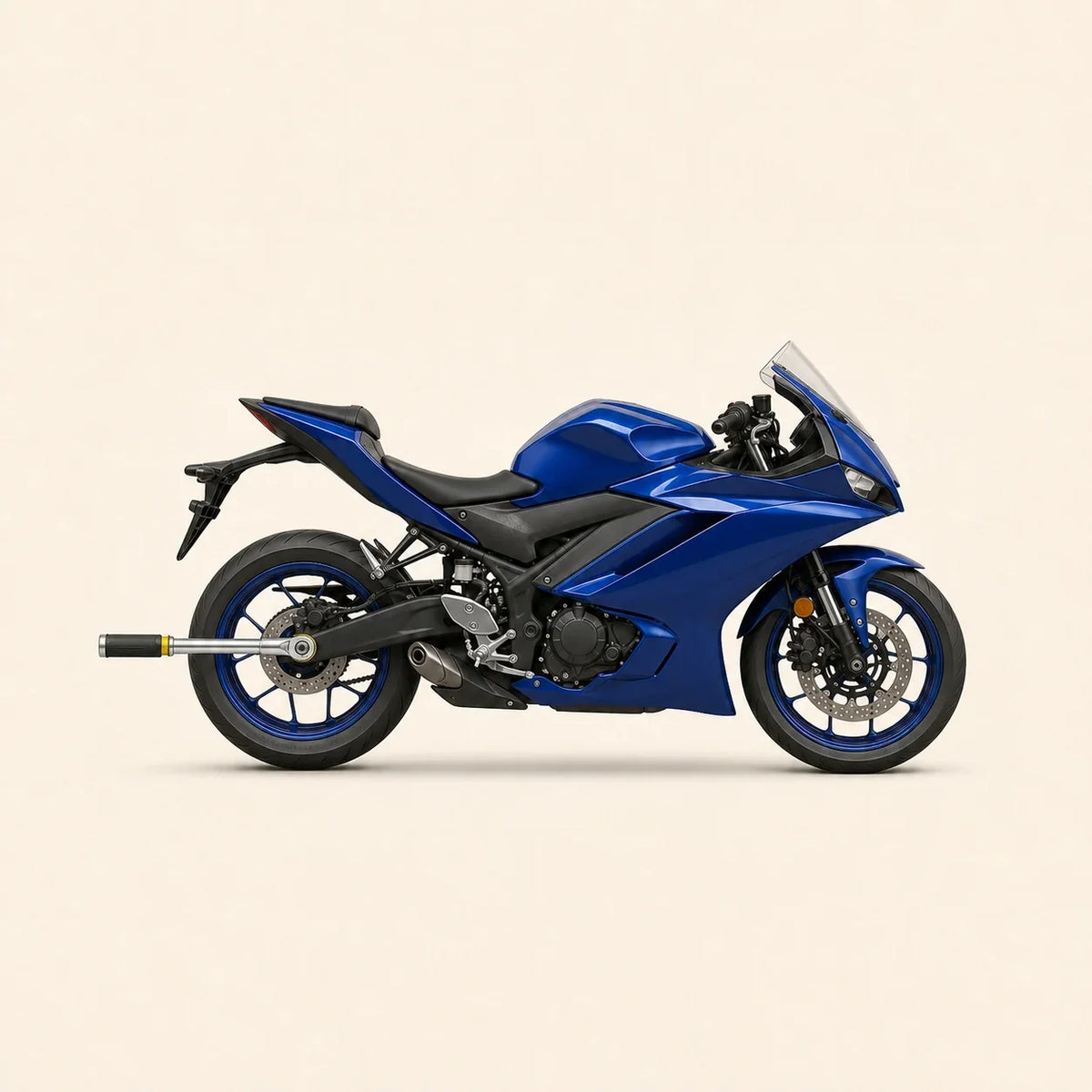 Yamaha R3 bleue de profil avec clé dynamométrique engagée sur l’écrou d’axe arrière