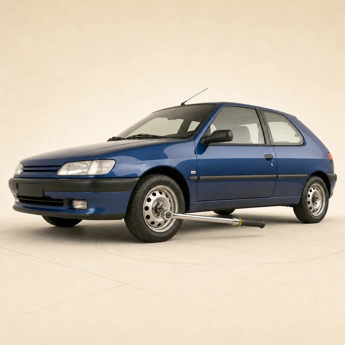 Peugeot 306 bleue avec une clé dynamométrique engagée sur une fixation de la roue avant