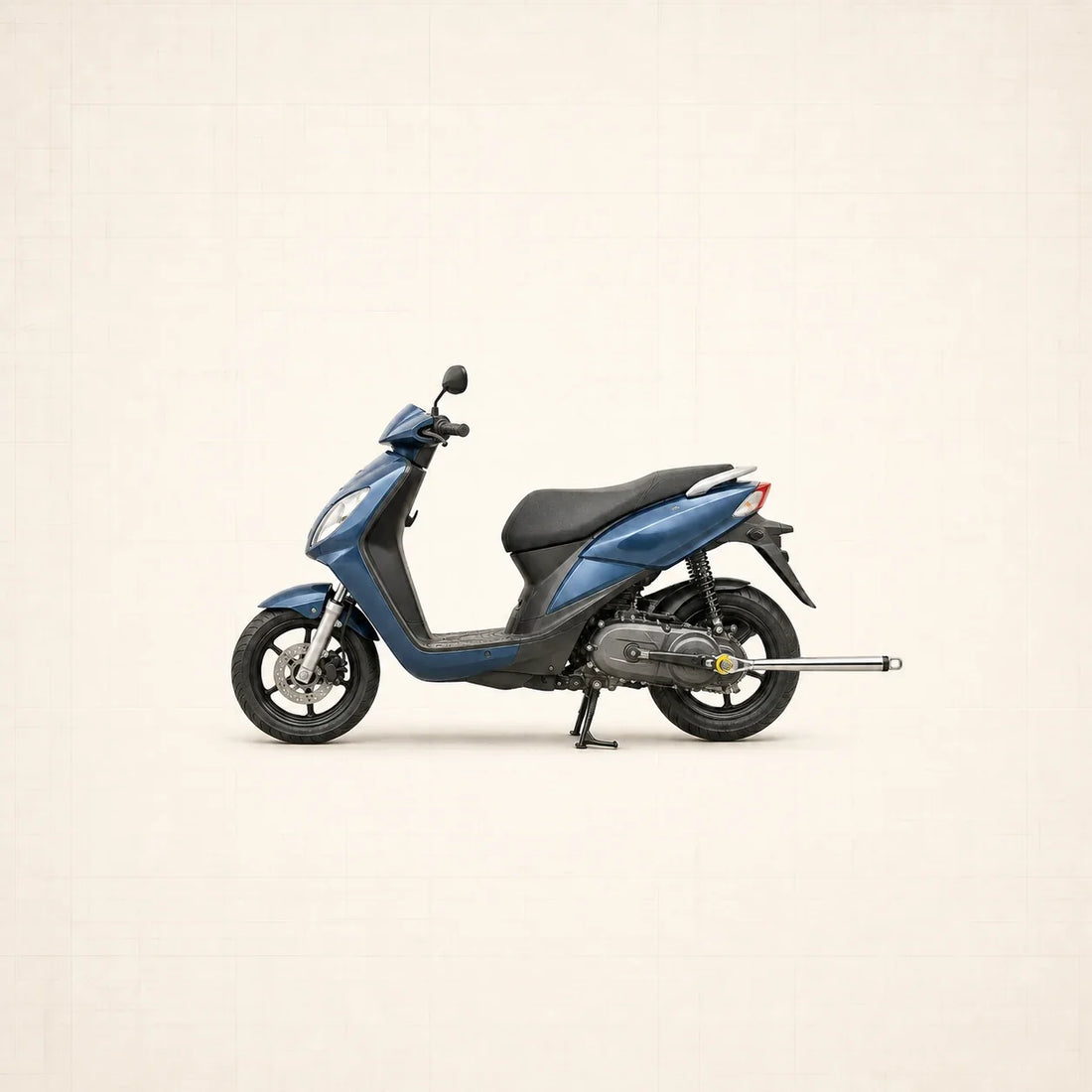 Scooter bleu vu de profil avec clé dynamométrique engagée sur l’écrou d’axe de roue arrière